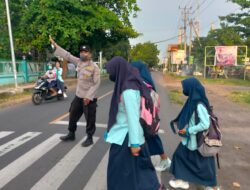 Polisi Bantu Anak Sekolah Menyebrang Jalan